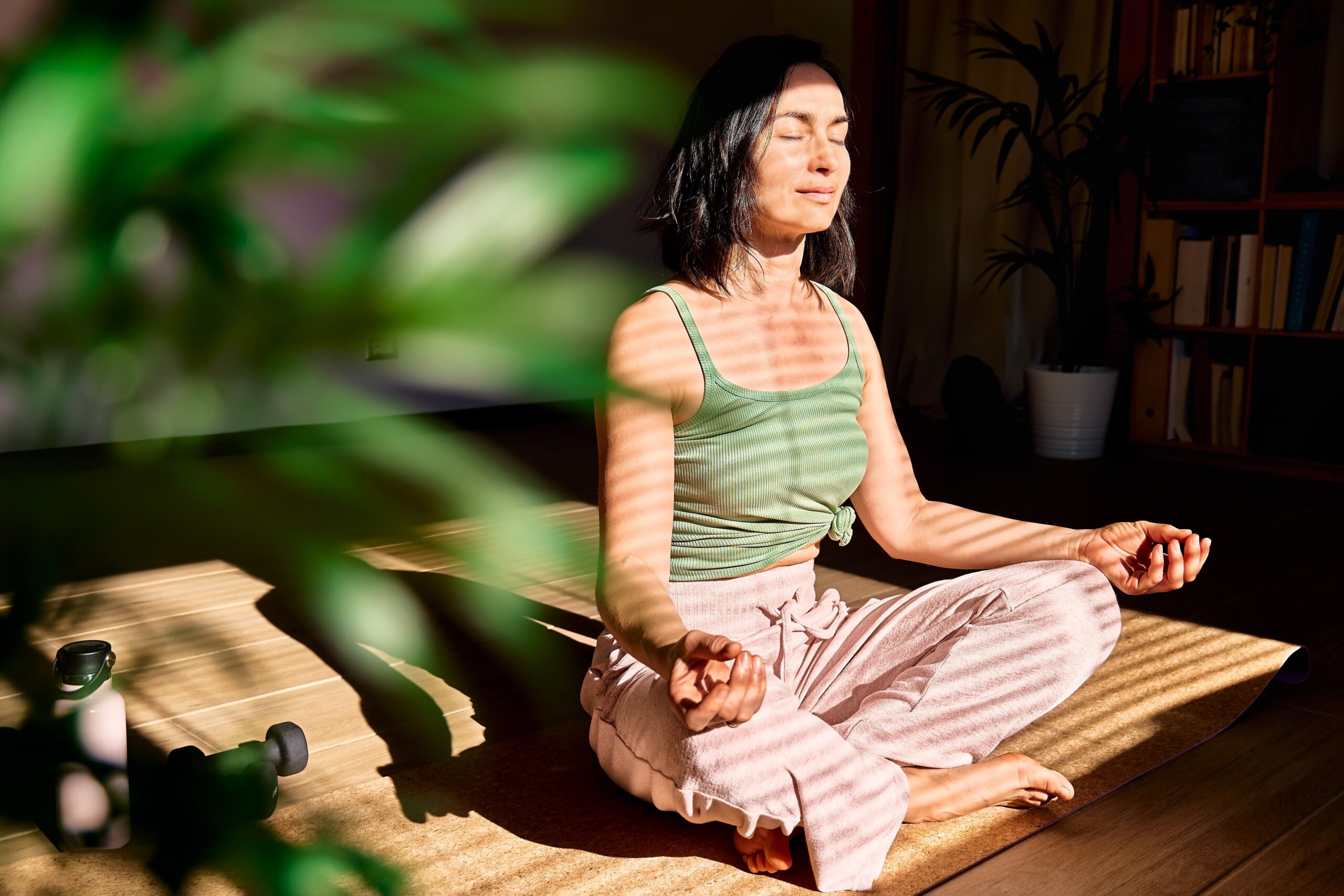 Individual practicing mindfulness meditation in a quiet indoor recovery setting Managing emotional triggers in recovery through meditation and mindfulness